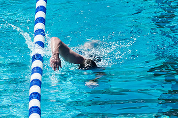 Mann schwimmt im Sportbecken